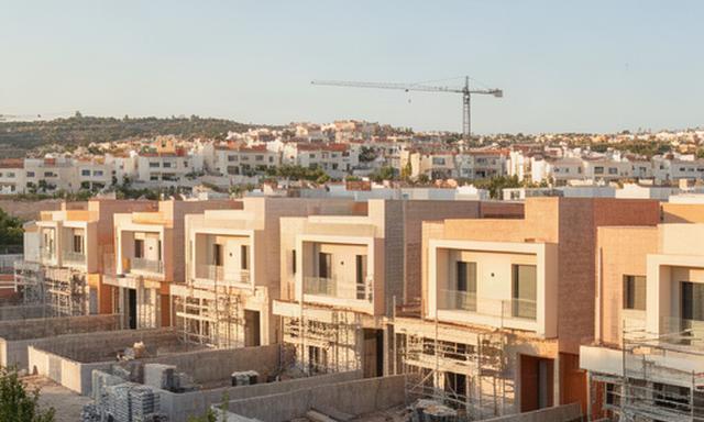 Promoción de adosados en construcción en L'Eliana con zona residencial al fondo